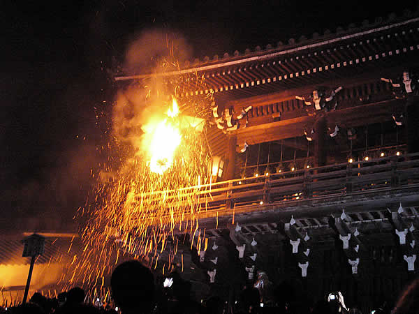 Fire and sparks rain down from the temple roof area.