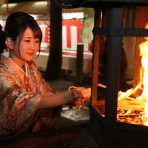 Okeramairi, Japanese Culture, A young woman lighting a rope to take home for good luck on New Year’s Eve in Kyoto., December in Japan