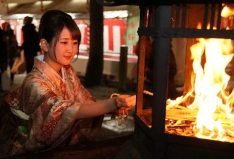 Okeramairi, Japanese Culture, A young woman lighting a rope to take home for good luck on New Year’s Eve in Kyoto., December in Japan