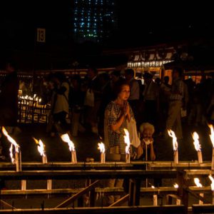 Japanese Culture, Japan in August, Bon Festival, People walking in a dark room lit by candles.