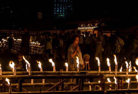Japanese Culture, Japan in August, Bon Festival, People walking in a dark room lit by candles.
