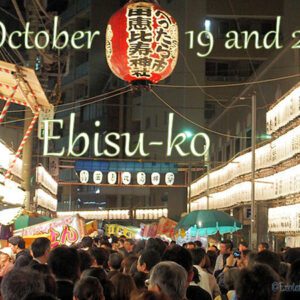 Japanese Culture, October in Japan, A huge red Japanese traditional lantern hanging high up flanked by rows of white lanterns with a huge crowd of festival goers beneath or Ebisu-ko.